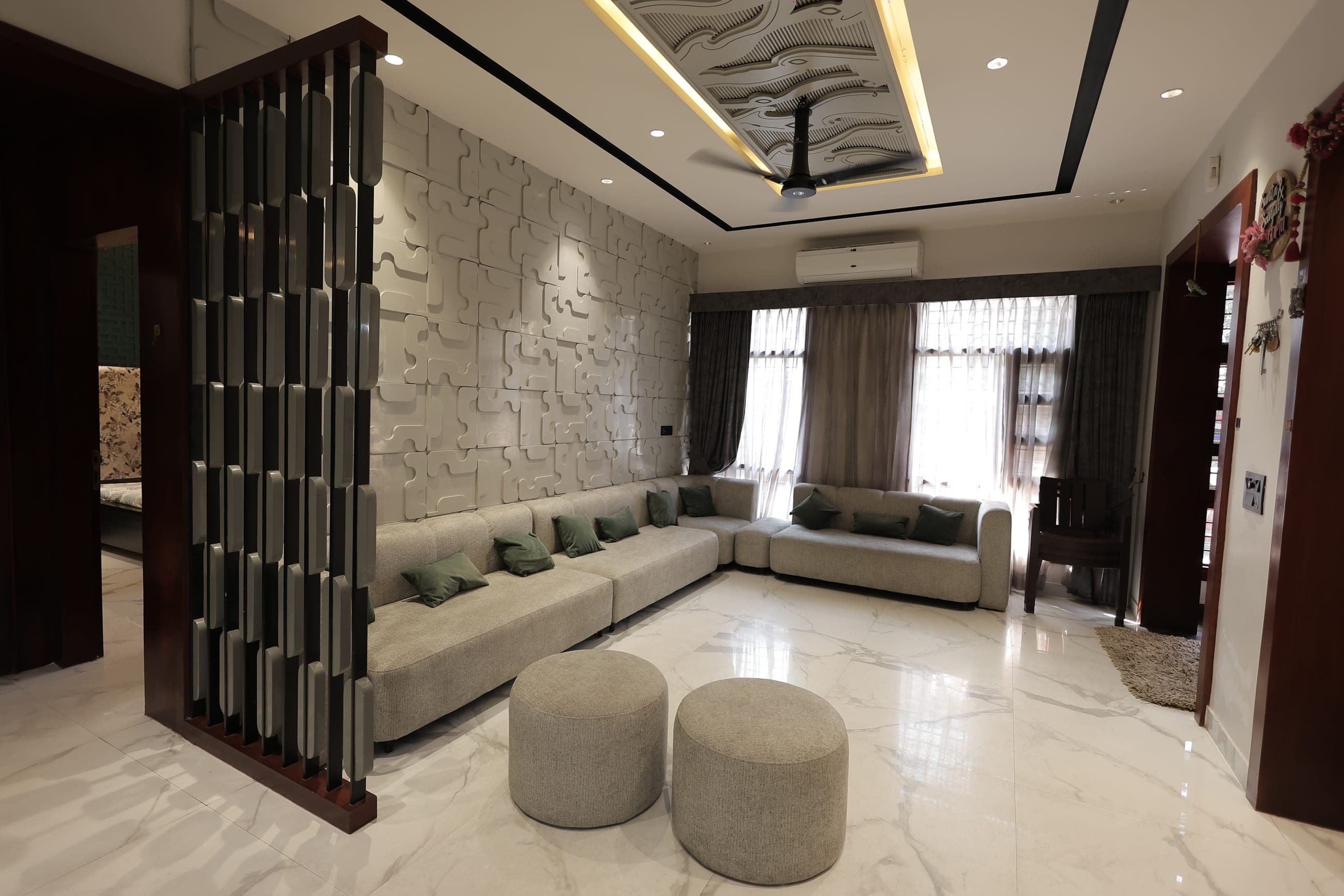 Living room with a sculptural feature wall in a Model Town residence, Yamunanagar